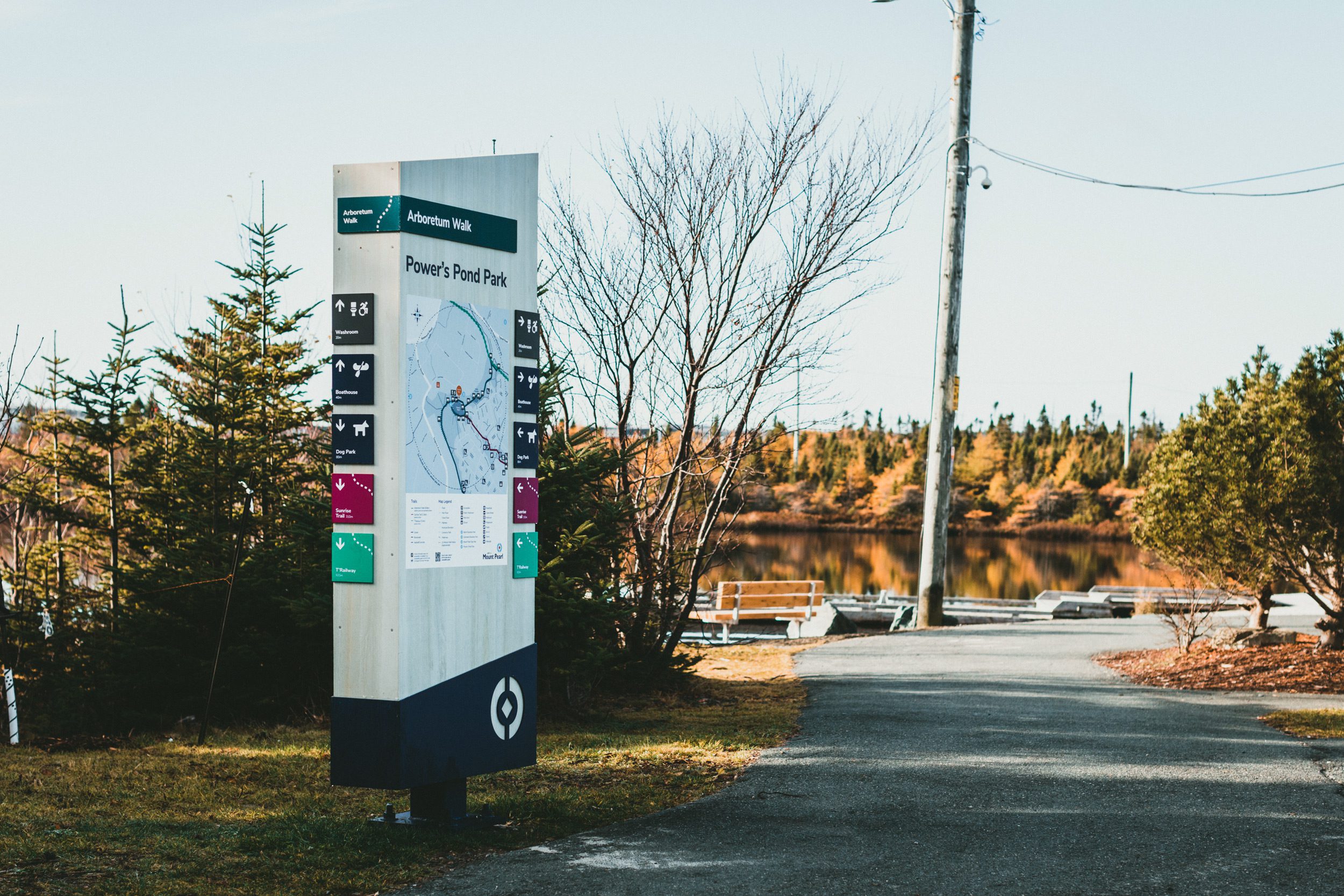 A Mount Pearl trail on a sunny fall day with a large information kiosk next to the trail